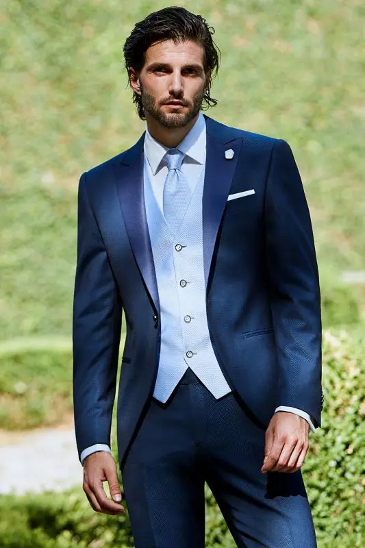 A man in a suit and tie standing outside.