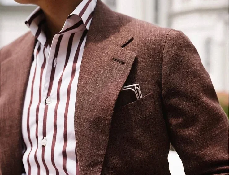 A man in a suit and striped shirt.