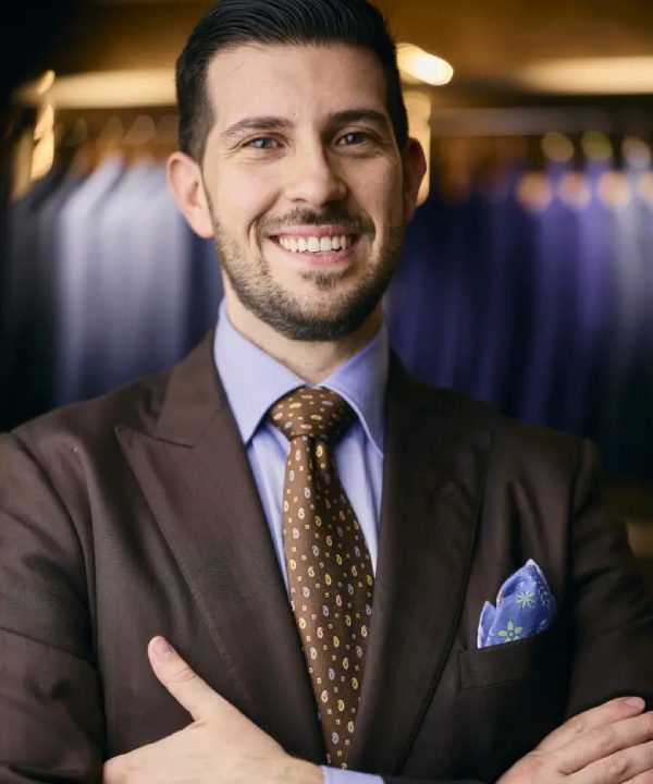 A man in a suit and tie smiling for the camera.