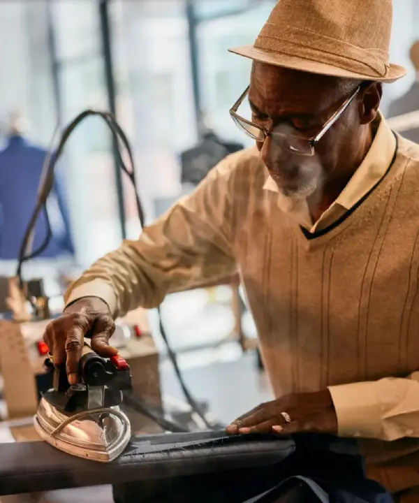 A man in glasses and hat working on electronics.