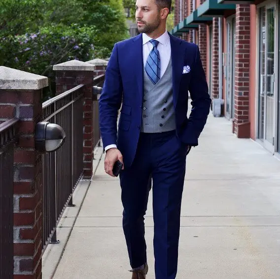 A man in a suit and tie walking down the sidewalk.