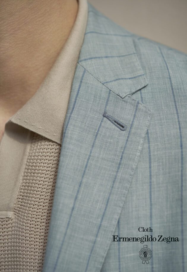 A close up of the lapel and sleeve of a suit.