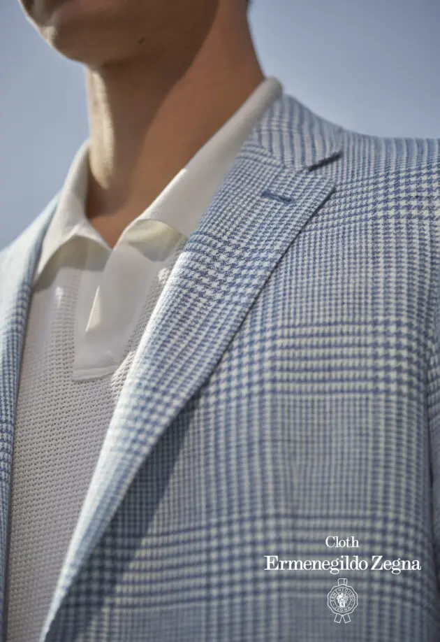 A man in a suit and tie with his shirt off.