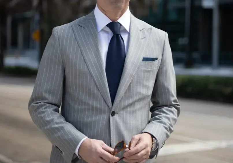 A man in a suit and tie standing outside.