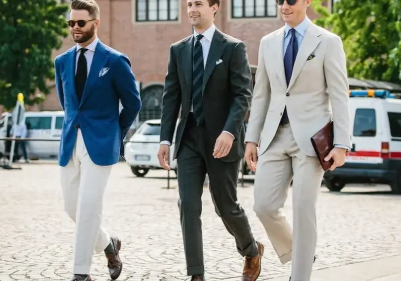 Three men in suits and ties walking down a street.