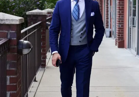 A man in a suit and tie walking down the sidewalk.