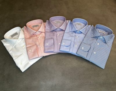 A row of different colored shirts on top of each other.
